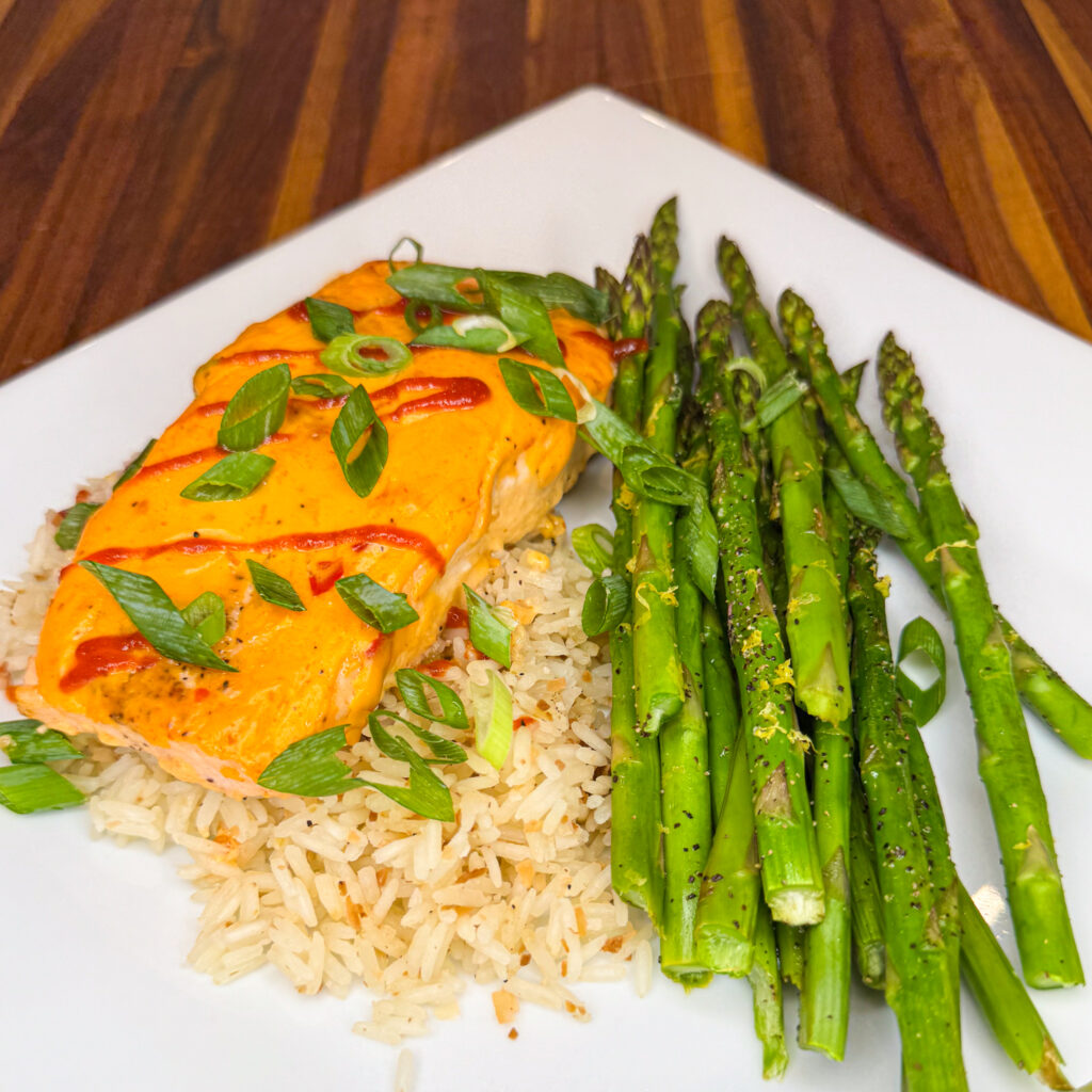 tender salmon topped with a zesty Thai sauce, paired with flavorful coconut rice and roasted asparagus for a deliciously balanced meal