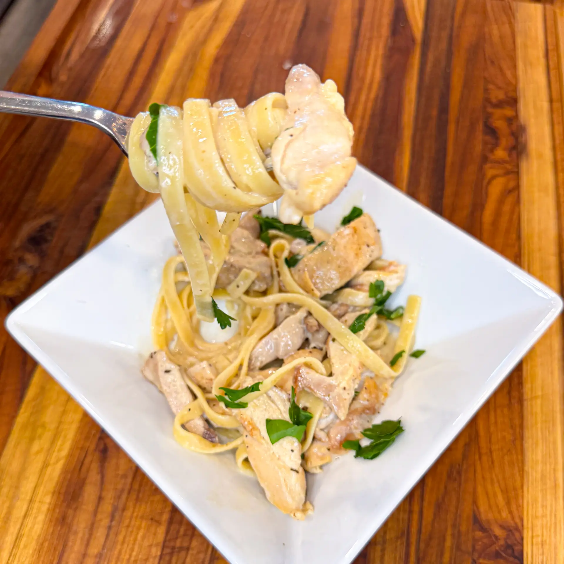 high protein fettuccine alfredo made with creamy cottage cheese, tender chicken thighs and topped with fresh parsely